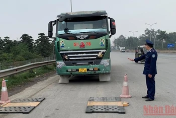 Lực lượng chức năng kiểm tra tải trọng xe tại khu vực cầu Thăng Long.