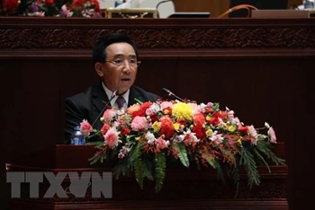 Thủ tướng Chính phủ Lào Phankham Viphavanh đọc báo cáo về tình hình thực hiện kế hoạch phát triển kinh tế-xã hội quốc gia trước Quốc hội. (Ảnh: Bá Thành/TTXVN)
