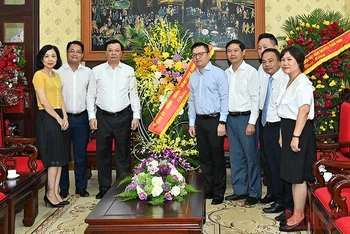 Bí thư Thành ủy Đinh Tiến Dũng tặng hoa chúc mừng Báo Nhân Dân nhân Ngày Báo chí cách mạng Việt Nam. (Ảnh: DUY LINH)
