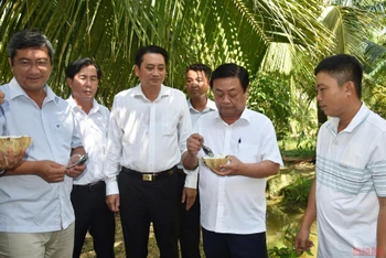 Bộ trưởng Nông nghiệp và Phát triển nông thôn Lê Minh Hoan tìm hiểu về trái dừa sáp tại cơ sở chế biến Đặng Minh Bé, xã Lương Hòa, huyện Châu Thành. 
