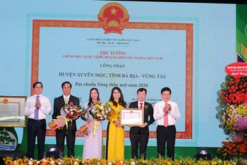 Phó Thủ tướng Thường trực Chính phủ Phạm Bình Minh trao bằng công nhận đạt chuẩn nông thôn mới cho lãnh đạo huyện Xuyên Mộc. (Ảnh: VGP)