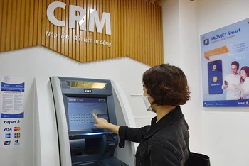 Khách hàng sử dụng dịch vụ ATM. (Ảnh: Trần Hải)