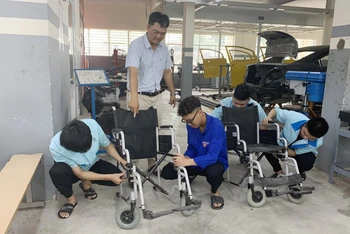 Thầy và trò sửa chữa xe lăn cho người khuyết tật 