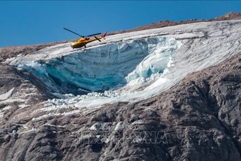 Trực thăng cứu hộ tìm kiếm nạn nhân tại hiện trường vụ lở tuyết trên núi Marmolada thuộc dãy Alps, Italia, ngày 4/7/2022. (Ảnh: AFP/TTXVN)