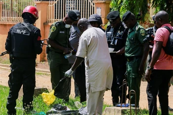 Cảnh sát kiểm tra vật dụng nghi là chất nổ bên ngoài Trung tâm giam giữ Kuje gần thủ đô Abuja, Nigeria, sau khi xảy ra vụ tấn công ngày 6/7/2022. (Ảnh: REUTERS)