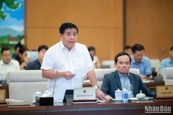 Bộ trưởng Kế hoạch và Đầu tư Nguyễn Chí Dũng trình bày Tờ trình của Chính phủ trong phiên họp sáng 13/10. (Ảnh: DUY LINH)
