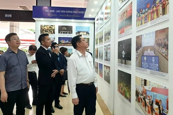 Đồng chí Nguyễn Trọng Nghĩa cùng các đại biểu tham quan khu trưng bày triển lãm lịch sử 61 năm quan hệ hữu nghị đặc biệt Việt Nam-Lào.