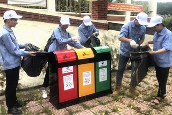 Đoàn viên, thanh niên thực hiện phân loại rác thải sinh hoạt trên hè phố TP Vĩnh Yên, tỉnh Vĩnh Phúc.