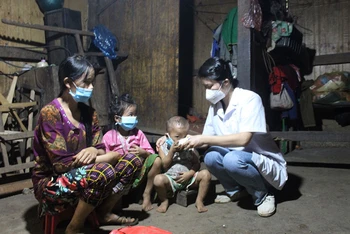 Cán bộ y tế hướng dẫn người dân thôn Phe Phà, xã Lũng Hồ, huyện Yên Minh, Hà Giang uống thuốc điều trị, phòng bệnh bạch hầu.