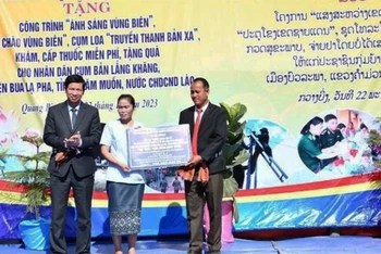 Đại diện lãnh đạo Ủy ban nhân dân tỉnh Quảng Bình trao bảng tượng trưng các công trình dân sinh tặng cụm bản Lẳng Khăng (Lào).