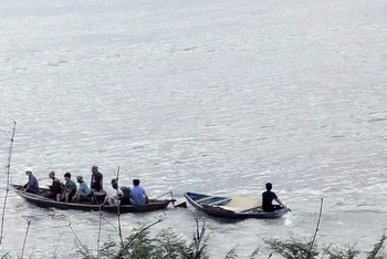 Lực lượng chức năng và người dân địa phương tổ chức tìm kiếm nạn nhân mất tích trên sông Vu Gia.