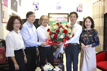 Phó Chủ tịch UBND thành phố Trần Chí Cường (thứ 2, bên phải) tặng hoa chúc mừng nhà văn Vĩnh Quyền. (Ảnh: V. Dũng)