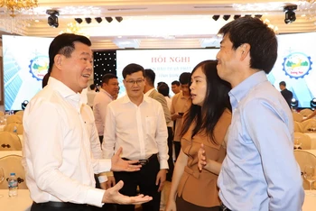 Bí thư Tỉnh ủy Đồng Nai Nguyễn Hồng Lĩnh (bên trái) trao đổi với doanh nghiệp tại một hội nghị. 