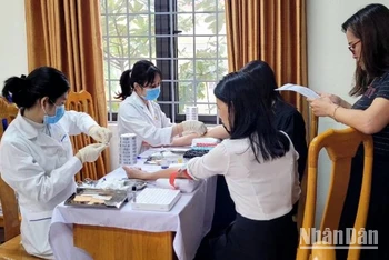 Nhân viên MEDLATEC Quảng Bình lấy mẫu xét nghiệm cho giáo viên một trường trung học phổ thông ở thành phố Đồng Hới.