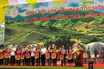 Các đồng chí lãnh đạo Huyện ủy, Ủy ban nhân dân huyện Nậm Pồ trao cờ lưu niệm tặng các đoàn tham gia Ngày hội.
