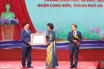 Đồng chí Đinh Tiến Dũng trao Huân chương Lao động hạng Nhất cho Phòng Giáo dục và Đào tạo quận Long Biên. (Ảnh: THANH TÙNG) 