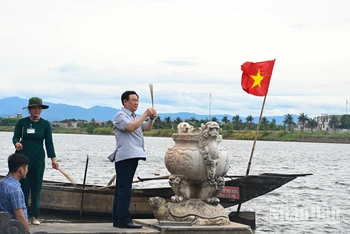 Chủ tịch Quốc hội Vương Đình Huệ thực hiện nghi lễ thả hoa tưởng niệm các anh hùng liệt sĩ trên dòng sông Thạch Hãn. (Ảnh Duy Linh)