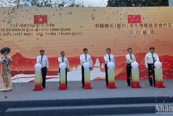 Các đại biểu thực hiện nghi thức vận hành thí điểm cho du khách qua lại tham quan thác Bản Giốc-Đức Thiên.