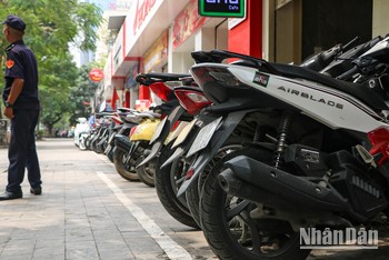 Vạch kẻ trắng phân chia chỗ để xe máy trên vỉa hè phố Láng Hạ. (Ảnh: Nhật Quang)