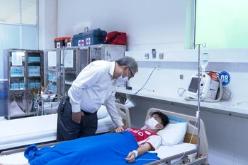 Lãnh đạo nhà trường thăm hỏi các em học sinh đang điều trị tại bệnh viện. (Ảnh: NGỌC HÒA)