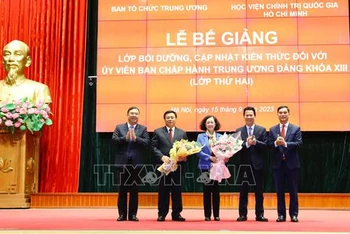 Ban tổ chức lớp tặng hoa cho đồng chí Trương Thị Mai và đồng chí Nguyễn Xuân Thắng. (Ảnh: TTXVN)