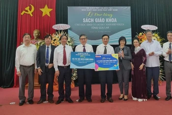 Bộ trưởng Giáo dục và Đào tạo Nguyễn Kim Sơn (thứ 3 từ trái sang) và đại diện Nhà xuất bản Giáo dục Việt Nam trao tặng bộ sách giáo khoa và Tủ sách dùng chung cho tỉnh Gia Lai.