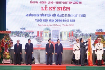 Chủ tịch nước Võ Văn Thưởng gắn Huân chương Hồ Chí Minh lên cờ truyền thống của tỉnh Long An. (Ảnh: Thống Nhất/TTXVN)