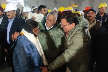 Thủ hiến bang Uttarakhand của Ấn Độ, ông Pushkar Singh Dhami (phải, phía trước) thăm hỏi sức khỏe một công nhân (trái, phía trước) vừa được giải cứu sau 17 ngày mắc kẹt trong đường hầm bị sập ở Uttarkashi, bang Uttarakhand, ngày 28/11/2023. (Ảnh: AFP/TTXVN)
