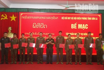 Đại tá Bàn Văn Chanh, Phó chỉ huy trưởng Bộ đội Biên phòng tỉnh Sơn La trao giấy chứng nhận cho các đồng chí học viên Lào. (Ảnh: Vì Hiện)