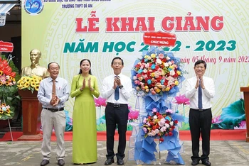 Chủ tịch UBND tỉnh Bình Dương Võ Văn Minh (bên phải) trao tặng hoa, chúc mừng khai giảng tại Trường THPT Dĩ An, thành phố Dĩ An, tỉnh Bình Dương. 