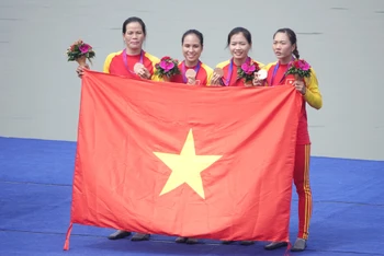 Các nữ vận động viên đội tuyển đua thuyền trên bục vinh quang. (Ảnh: Nam Trung)