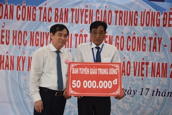Đồng chí Phan Xuân Thủy trao 50 triệu đồng cho thầy và cô Trường tiểu học Nguyễn Thị Tốt.