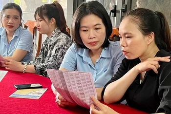 Cán bộ Bảo hiểm xã hội thị xã Ba Ðồn (Quảng Bình) tuyên truyền chính sách bảo hiểm xã hội tự nguyện cho người dân. 
