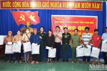 Đại diện Ban Quản lý dự án 46 và chính quyền địa phương trao tặng quà cho các gia đình chính sách, hộ nghèo trên địa bàn xã Cư San, huyện M’Đrắk.