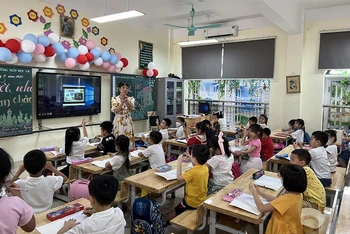 Giáo viên Trường tiểu học và THCS Hoàng Hoa Thám (thành phố Bắc Ninh, tỉnh Bắc Ninh) hướng dẫn học sinh cầm bút. (Ảnh THÚY QUỲNH)