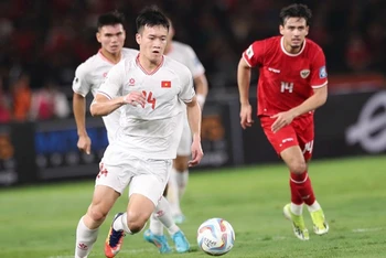 Pha tranh bóng giữa cầu thủ đội tuyển Việt Nam (áo trắng) và Indonesia ở trận lượt đi trên sân Bung Karno. (Ảnh VFF)