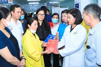 Lãnh đạo thành phố Hà Nội thăm hỏi, hỗ trợ người nhà nạn nhân vụ cháy đang điều trị tại bệnh viện. (Ảnh QUANG THÁI)
