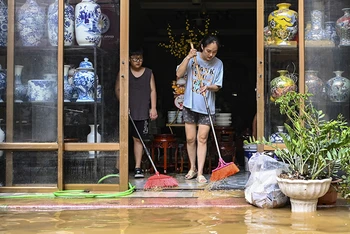 Sáng 13/9, nhiều hộ dân, tiểu thương tại xã Bát Tràng, huyện Gia Lâm, Hà Nội dọn dẹp bùn đất sau khi nước xuống. (Ảnh QUANG TÙNG)