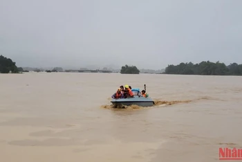 Lực lượng chức năng khẩn trương giúp người dân trong mưa lũ.