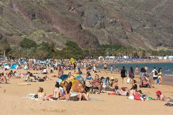 Người dân tránh nóng trên bãi biển ở Santa Cruz de Tenerife, Tây Ban Nha. (Ảnh: AFP/TTXVN)