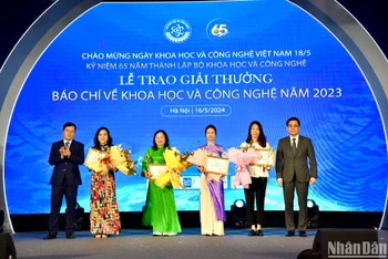 Thứ trưởng Khoa học và Công nghệ Nguyễn Hoàng Giang, Trưởng Ban Tổ chức xét tặng Giải thưởng báo chí về khoa học và công nghệ năm 2023 và Thứ trưởng Thông tin và Truyền thông Nguyễn Thanh Lâm trao giải Nhất cho các tác giả, đại diện nhóm tác giả đoạt giải. (Ảnh: NHẬT QUANG)