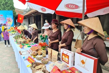 Người dân làng cổ Đường Lâm giới thiệu những đặc sản địa phương phục vụ khách du lịch.