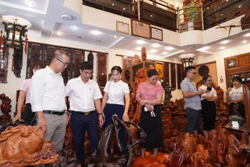Các đại biểu tham gia hội nghị tham quan sản phẩm gỗ mỹ nghệ tại xã Vân Hà.