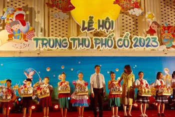 Lãnh đạo Uỷ ban nhân dân quận Hoàn Kiếm trao quà cho các em học sinh.