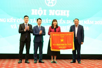 Bộ trưởng Văn hóa, Thể thao và Du lịch Nguyễn Văn Hùng trao cờ thi đua cho đại diện lãnh đạo Sở Du lịch Hà Nội.