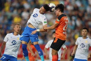 Pha tranh bóng quyết liệt giữa cầu thủ hai đội Nam Ðịnh (áo trắng) và SHB Ðà Nẵng. (Ảnh VPF) 