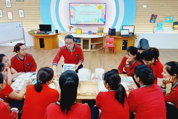 Cô giáo Ðào Thị Nhung chia sẻ với đồng nghiệp quy trình làm ra một bộ sách bóc dán. 