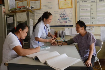 Khám chữa bệnh, cấp phát thuốc bảo hiểm y tế cho người dân tại Trạm y tế xã Phong Nậm, huyện Trùng Khánh, tỉnh Cao Bằng. (Ảnh TUỆ NGHI)