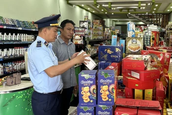 Lực lượng quản lý thị trường tỉnh Ninh Thuận giám sát hàng hóa phục vụ dịp Tết Nguyên đán Giáp Thìn 2024 tại một cửa hàng tạp hóa trên địa bàn. (Ảnh Trần Khoa) 