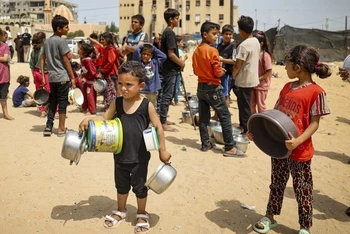 Trẻ em mất nhà cửa ở Gaza chờ nhận hàng cứu trợ. 